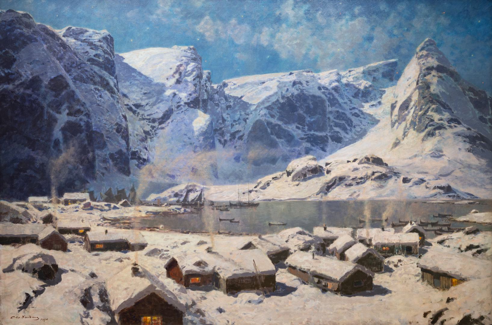 Et snødekket landskap med store fjell, speilblank fjord og blå himmel. I forgrunnen småhus hvor det lyser i vinduer og røyken stiger fra husenes piper. Bilder uttrykker en kald vinterdag fra Reine i Lofoten